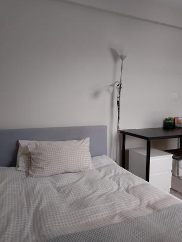 a bedroom with a bed with a table and a desk at Double or twin room in town centre in East Grinstead