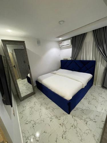 a bedroom with a blue bed and a mirror at Wine House, Maitama, Abuja in Abuja