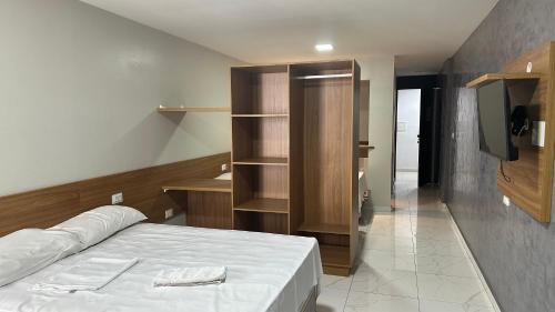 a small bedroom with a bed and a tv at Victory Flat Tambaú BR in João Pessoa