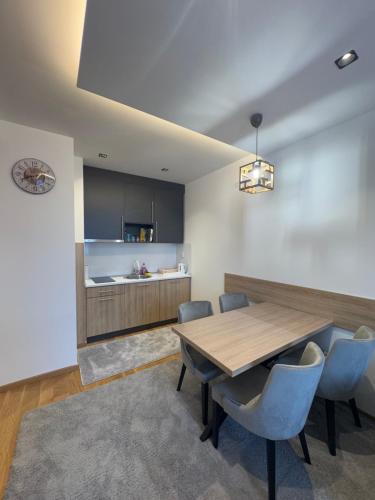 a kitchen and dining room with a wooden table and chairs at Zlatni Javor 211 in Jahorina