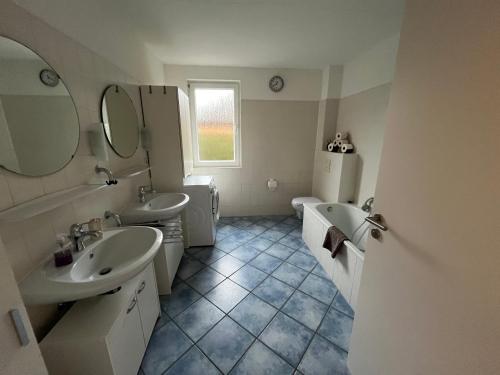 un bagno con due lavandini e due specchi di Ferienwohnung Sonnenschein Garten a Uelzen