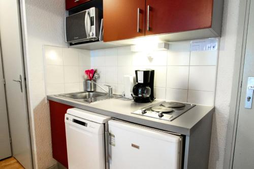 une petite cuisine avec un évier et une cuisinière dans l'établissement Résidence Les Portes De La Vanoise - LES PORTES DE LA VANOISE - SB507A MAE-3062, à Villarodin-Bourget