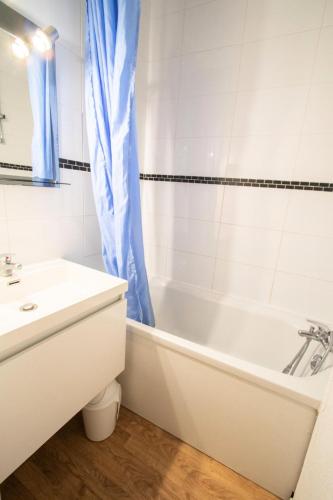 une salle de bain avec une baignoire blanche et un lavabo dans l'établissement Résidence Les Portes De La Vanoise - LES PORTES DE LA VANOISE - SB507A MAE-3062, à Villarodin-Bourget