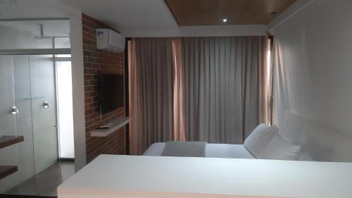 a hotel room with a bed and a television at Reserva Madero 201 Vista Mar in Natal