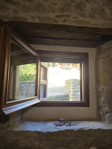 a window in a room with a stone wall at El Racó dels Mussols 2 in Adri