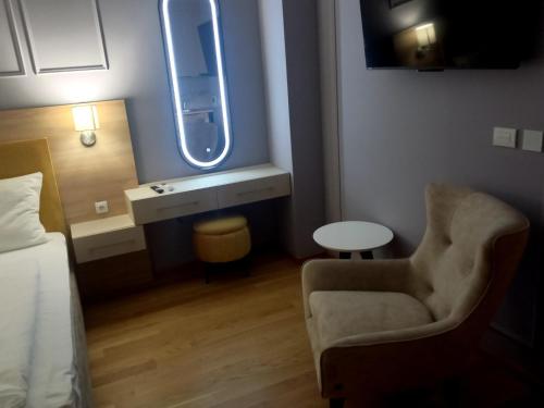 a room with a bed and a chair and a window at MN apartman in Banja Luka
