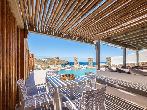 a table and chairs on a balcony with a view of the ocean at Mykonos Residence Villas & Suites Merchia beach in Merchia Beach