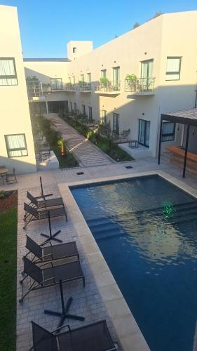 a swimming pool in the middle of a building with chairs at Hotel Boutique Gualamba in General Pinedo