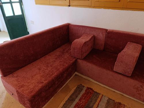 a red couch sitting in the corner of a room at Bostan studio in Fayoum Center