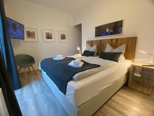 een slaapkamer met een groot bed met twee handdoeken erop bij Meerblick, Balkon und private Sauna im historischen Getreidespeicher in Wismar