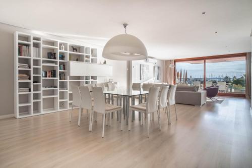 a dining room and living room with a table and chairs at Luxury sea view Apartment in Puerto de Alcudia in Alcudia