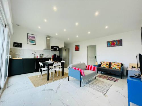 a living room with a couch and a table at Jacuzzi privé 500m de la mer in Blainville-sur-Mer