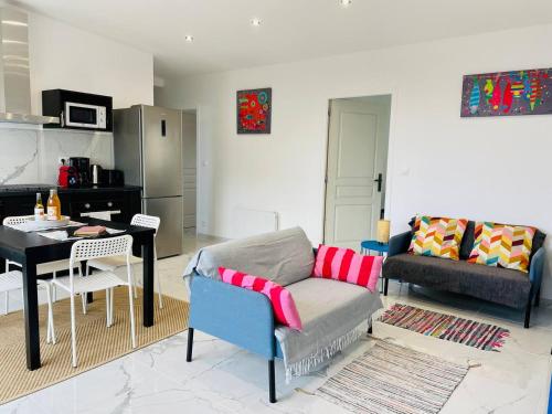 a living room with a couch and a table at Jacuzzi privé 500m de la mer in Blainville-sur-Mer