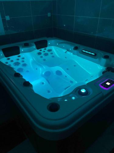La salle de bains est pourvue d'une baignoire jacuzzi avec des lumières bleues. dans l'établissement Jacuzzi privé 500m de la mer, à Blainville-sur-Mer