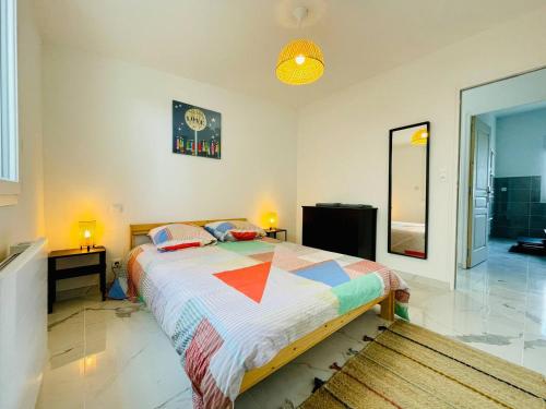 une chambre avec un lit avec une couette colorée dans l'établissement Jacuzzi privé 500m de la mer, à Blainville-sur-Mer