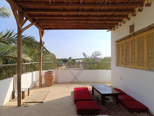 a patio with a table and a bench on a balcony at Bostan studio in Fayoum Center