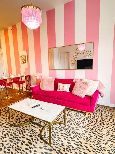 a living room with a pink couch and a table at Dolly's Delight - Boutique Bliss Mins From Broadway in Nashville