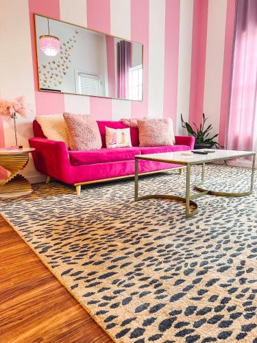 a living room with a pink couch and a rug at Dolly's Delight - Boutique Bliss Mins From Broadway in Nashville