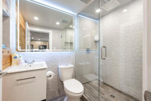 a bathroom with a toilet and a glass shower at Whistler Village Center - Newly Renovated Condo in Whistler