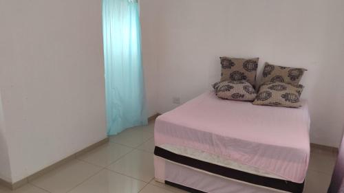 Una cama con almohadas en una habitación. en Discovery Guest House, en Roodepoort