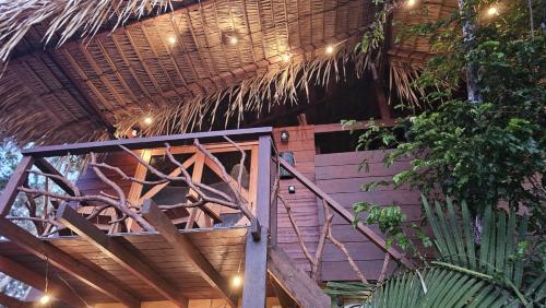 a building with a thatched roof with a staircase at Chalé da Floresta 1 in Santarém