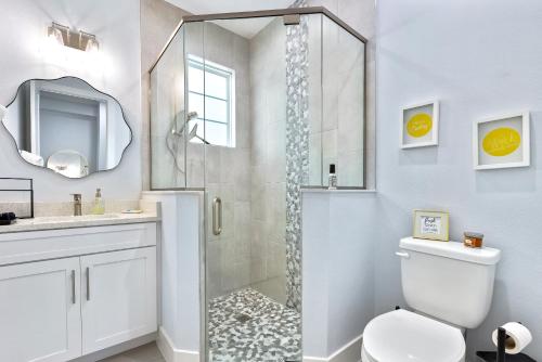 une salle de bain avec une douche avec des toilettes et un lavabo dans l'établissement Sunset Oasis - Luxury Pool Home - 350 Feet to the Beach, à New Smyrna Beach
