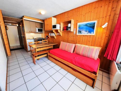 a living room with a red couch and a kitchen at Résidence Villaret - studio cabine pour 4 personnes vue sur les pistes MAE-5414 in Les Menuires