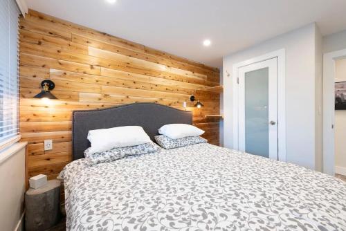 a bedroom with a bed with a wooden wall at Whistler Village Center - Newly Renovated Condo in Whistler