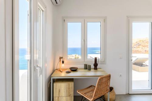 a home office with a desk and views of the ocean at Mykonos Residence Villas & Suites Merchia beach in Merchia Beach