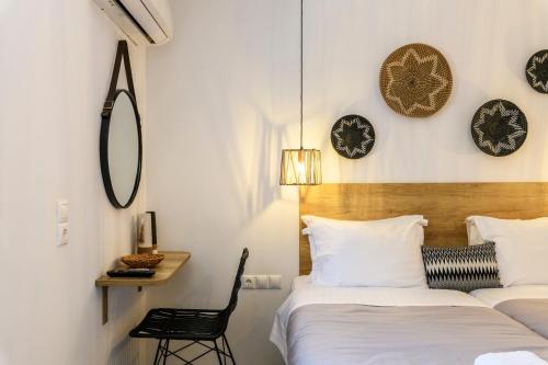 two beds in a room with clocks on the wall at Mykonos Residence Villas & Suites Merchia beach in Merchia Beach