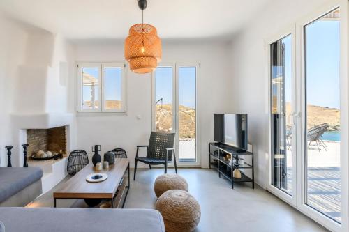 a living room with a couch and a tv at Mykonos Residence Villas & Suites Merchia beach in Merchia Beach