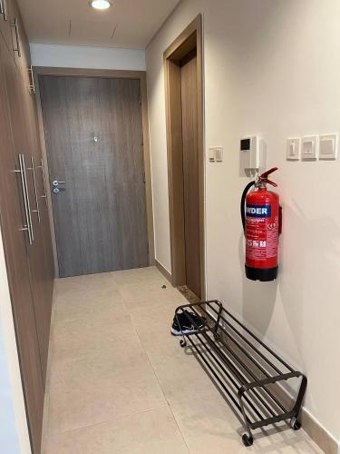a fire extinguisher on the wall of a hospital hallway at Cozy Studio - Your Comfort First! in Abu Dhabi