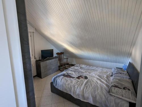1 dormitorio con 1 cama con techo blanco en Casa 2112, en Sestola