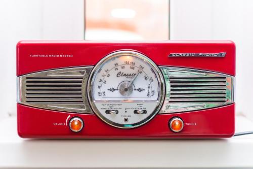 a red radio with a speedometer on a table at Retro Hostel in Poznań