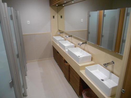 a bathroom with three sinks and a mirror at Hotel Viña Del Mar in Rio de Janeiro