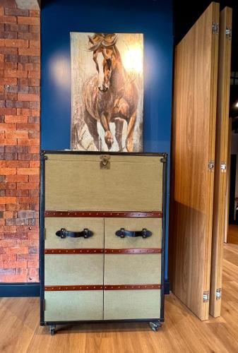 a dresser with a painting of a horse on it at Tribeca 402 in Gramado