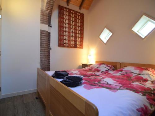 a bedroom with a bed with flowers on it at Romantic Farmhouse Escape in Geesteren
