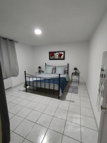 une chambre avec un lit et un sol carrelé dans l'établissement Maison Plume, à Nîmes