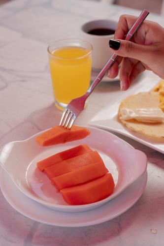 een persoon met een vork en een bord voedsel bij Hotel Kaamú Taganga in Taganga