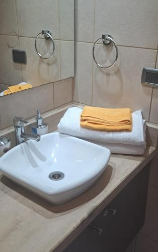 Un baño con un lavabo blanco y un espejo. en Sunset Providencia, en Santiago
