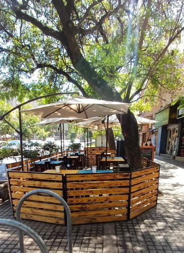 una mesa con un paraguas blanco y un árbol en Sunset Providencia, en Santiago