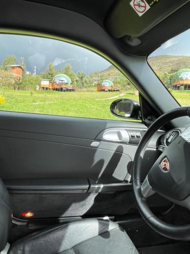 a view of a car dashboard with a view of a field at Glamping Brillo de Luna in Guatavita