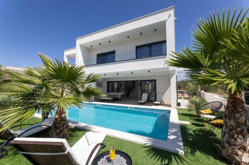 een villa met zwembad en palmbomen bij Villa Golden Shine in Primošten
