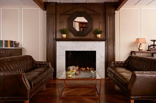 a living room with two couches and a fireplace at The Gregorian New York City in New York