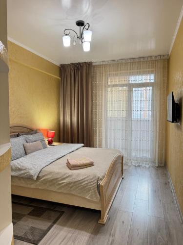 a bedroom with a large bed and a window at For Family Full Apartment near AirPort in Chişinău