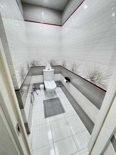 a white bathroom with a toilet in a room at For Family Full Apartment near AirPort in Chişinău