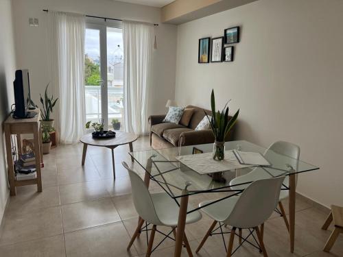 een woonkamer met een glazen tafel en stoelen bij Departamento Venthos in Puerto Madryn