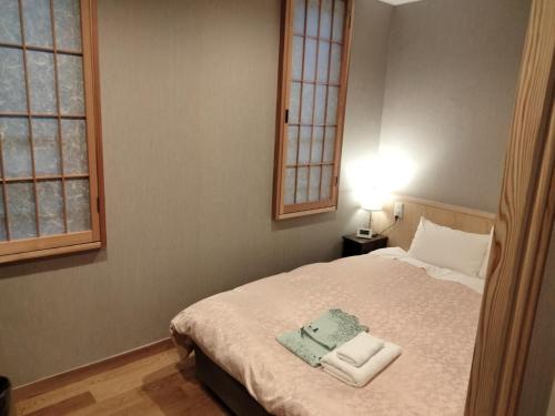 a bedroom with a bed with two towels on it at Hotel Hanakomichi - Vacation STAY 27567v in Nara