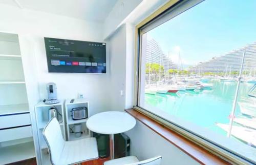 un tavolo e una sedia in una stanza con finestra di #A1K STUDIO JUNIOR - MARINA RIVIERA BAY Near Airport a Villeneuve-Loubet
