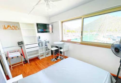 una camera da letto con un letto, una scrivania e una finestra di #A1K STUDIO JUNIOR - MARINA RIVIERA BAY Near Airport a Villeneuve-Loubet